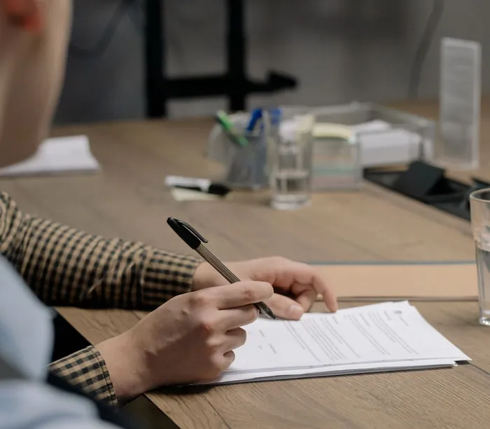 Une personne signe un document contractuel.