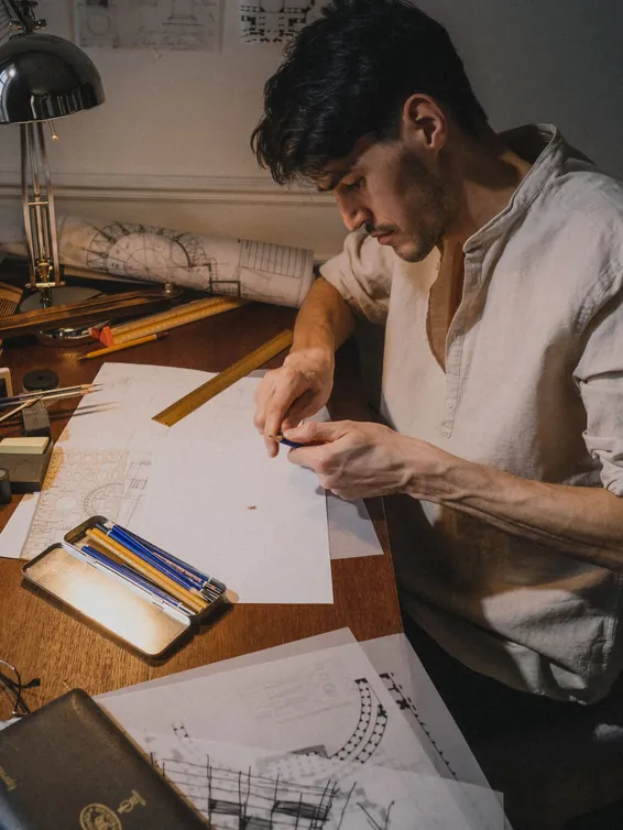 Un homme travaille sur des plans à son bureau.
