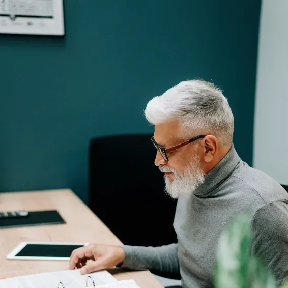 Un homme relit des documents à son bureau.