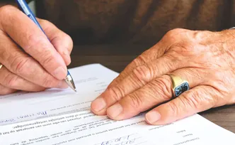 Une personne signe un document.